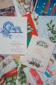 A display of various Christmas card styles and sizes arranged artfully on a rustic wooden shelf.