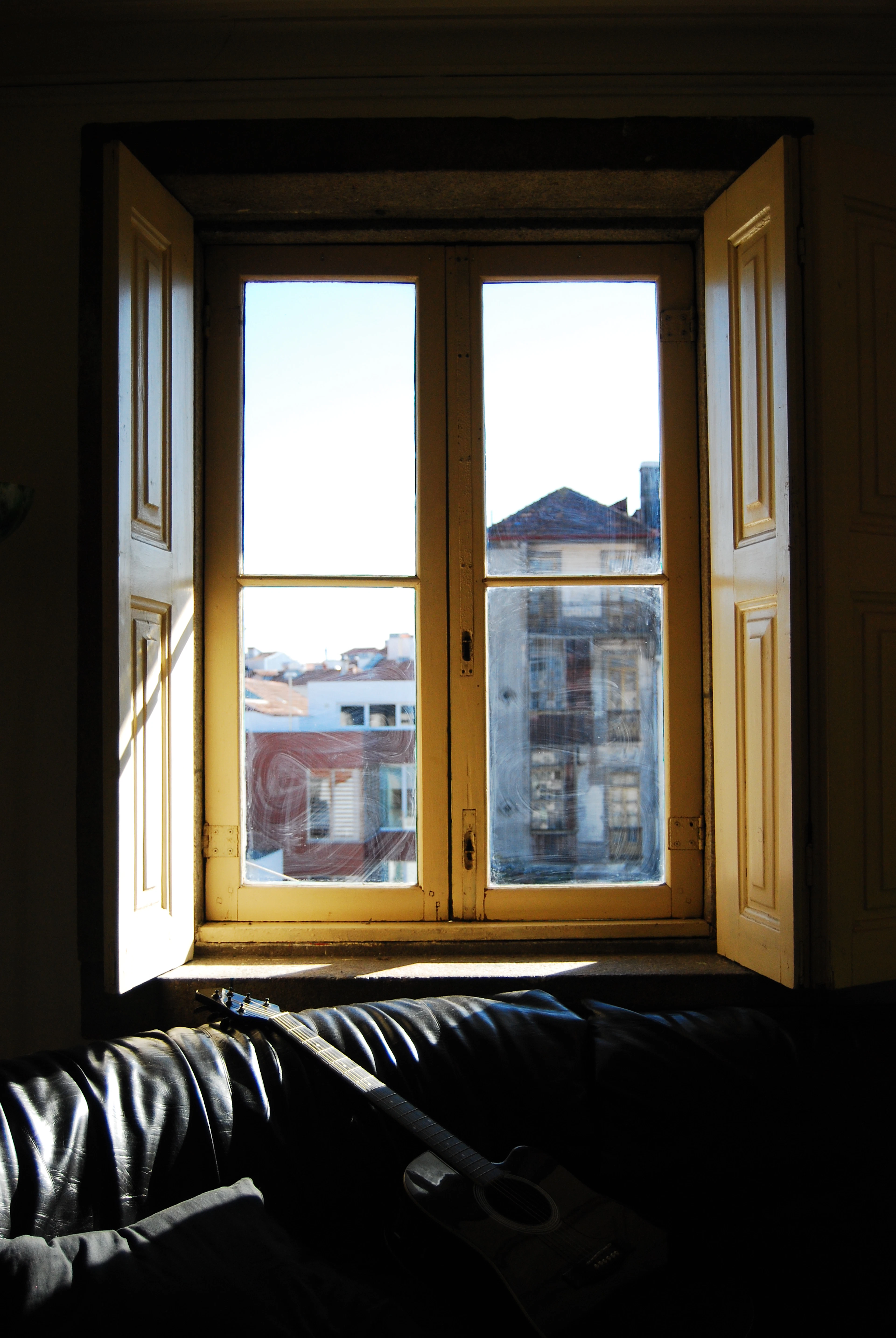 Morning light through tall wooden shutters, looking out onto the facades across the street
