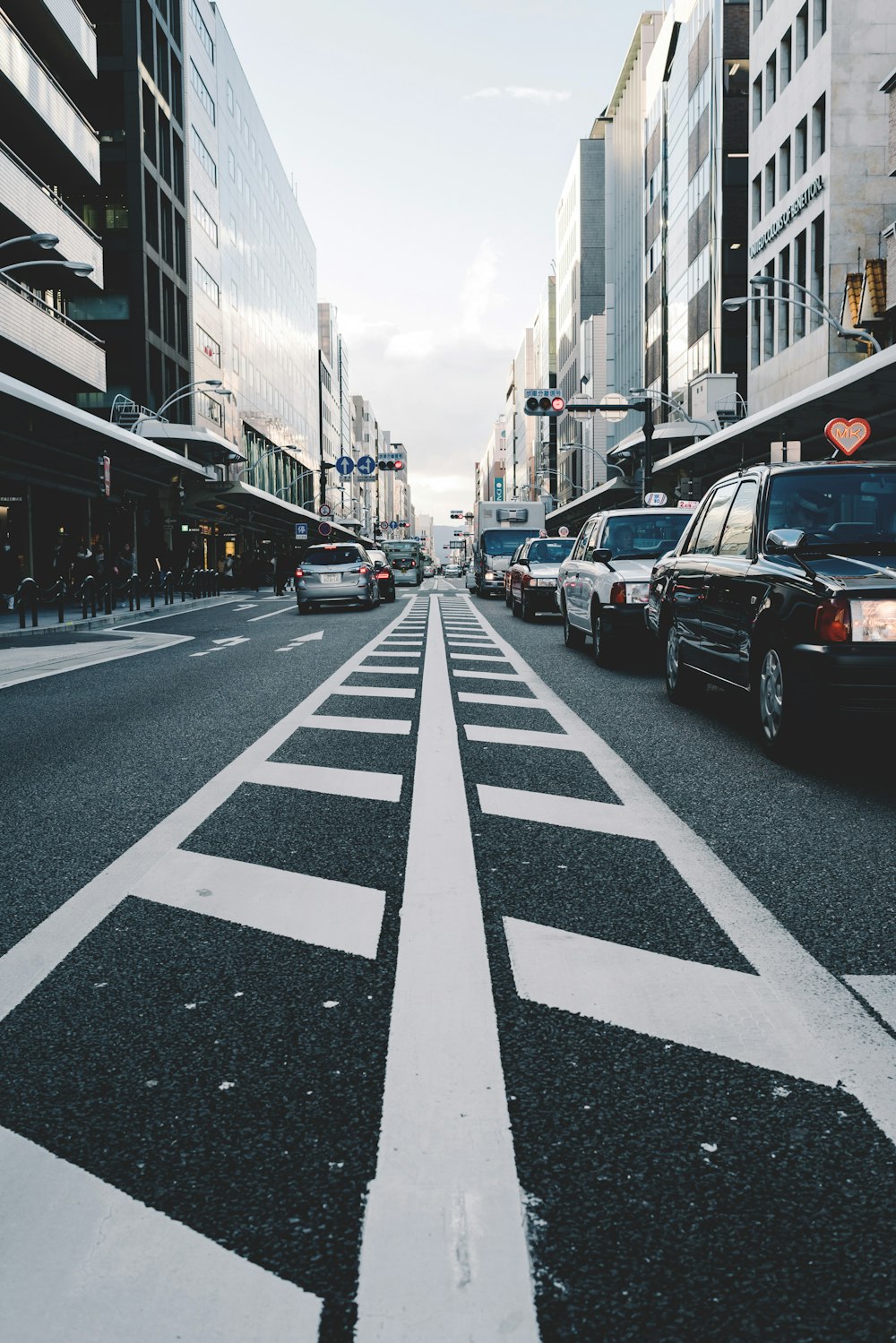 vehicles on road between buildings