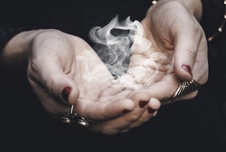 Gentle hands releasing a swirl of violet energy in a calm, dimly lit room.