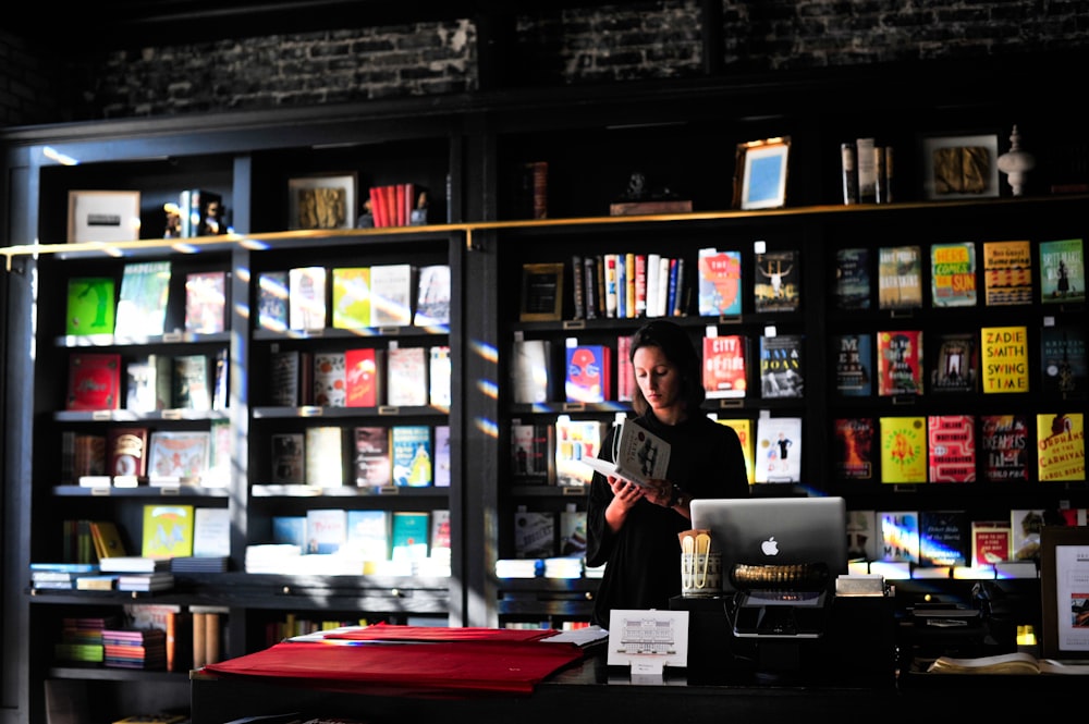 mulher em pé na frente da estante de livros