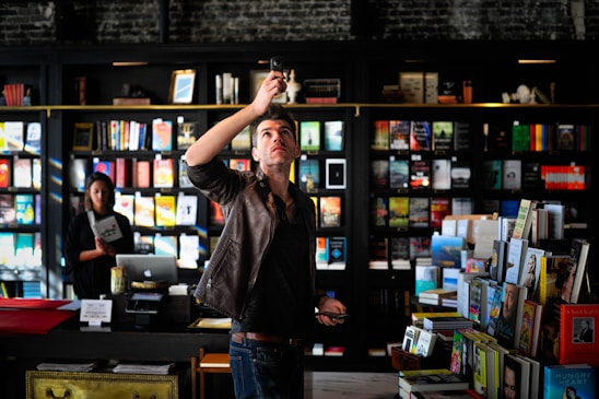 man holding black phone talking photo inside room