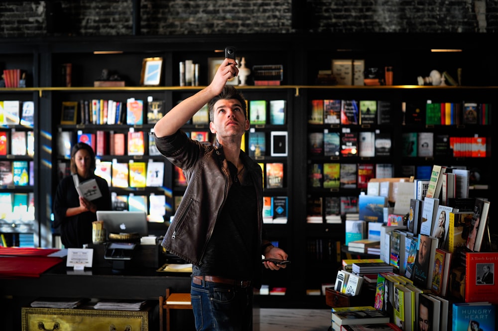 man holding black phone talking photo inside room