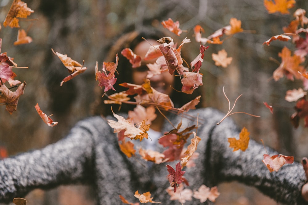 woman throwing maple leaves