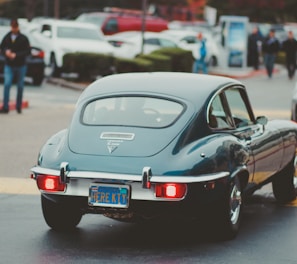 teal coupe passing by in street