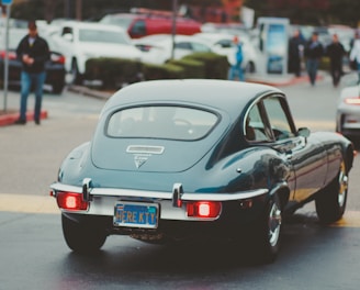 teal coupe passing by in street