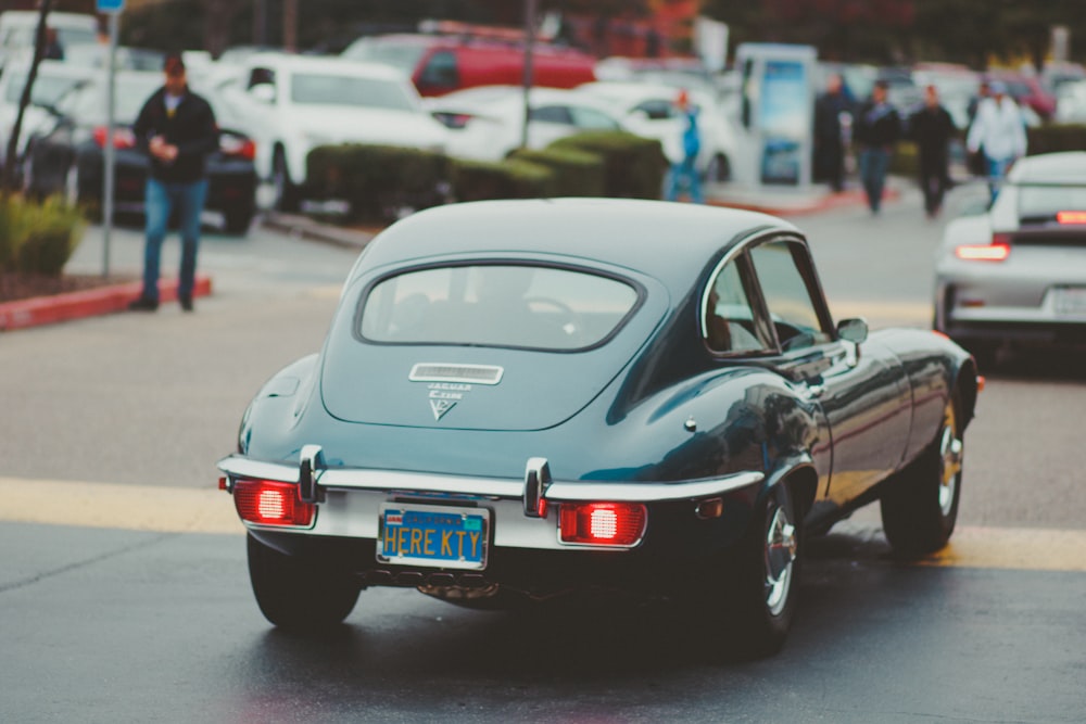 teal coupe passing by in street