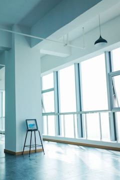 Modern urban loft interior with large windows and minimalist decor.