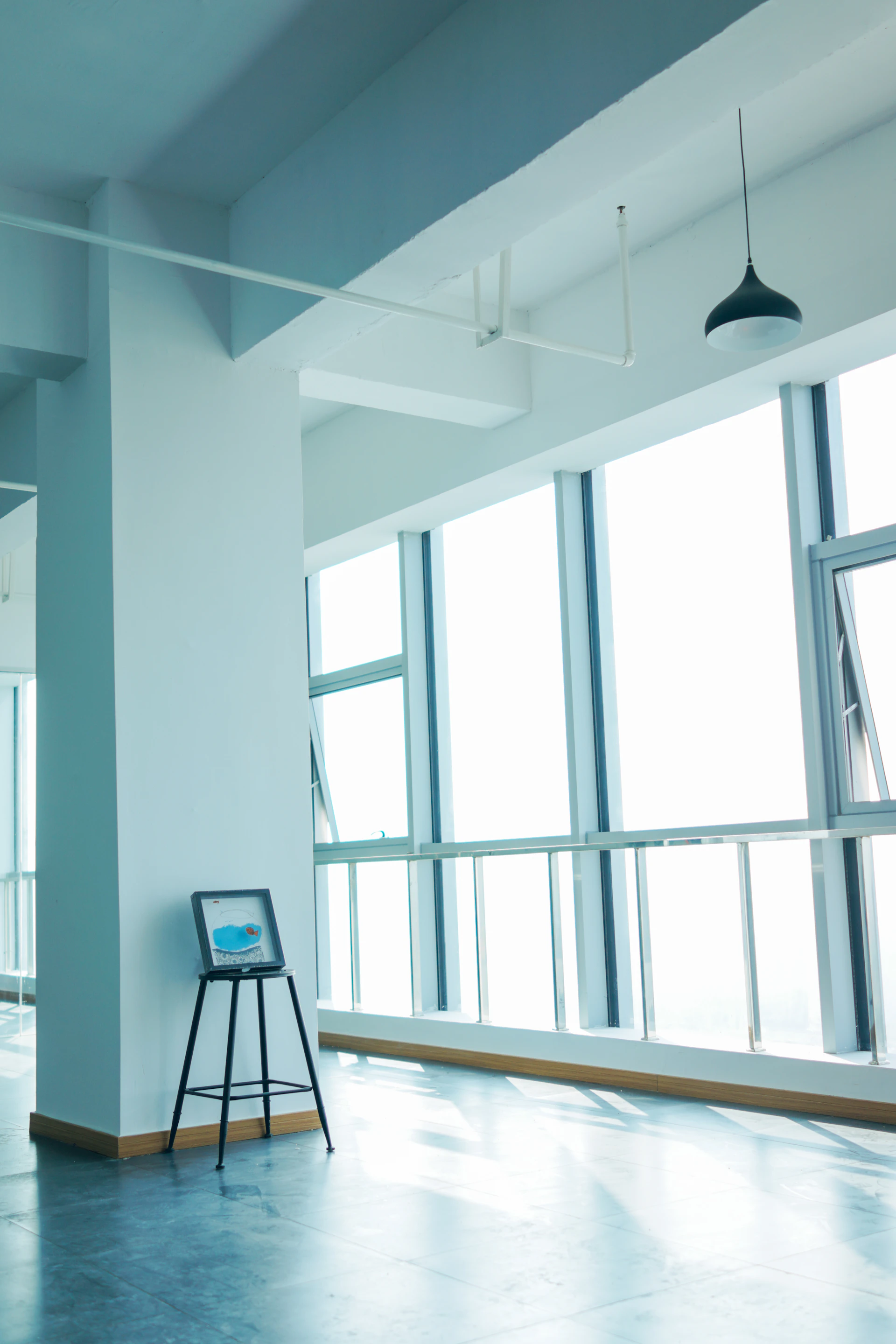 A sleek, high-resolution photograph capturing the minimalist interior of a modern art studio with soft natural light.