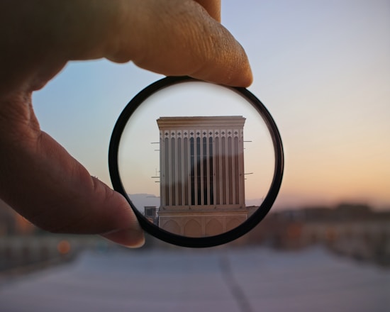A sleek camera lens focused on a stylish modern building at dusk with soft shadows.