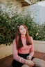 woman sitting near pink flowers at daytime