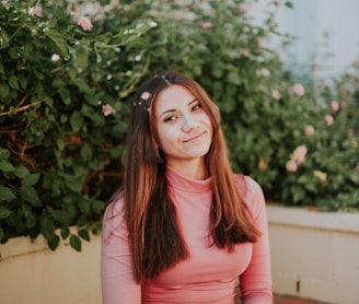 woman sitting near pink flowers at daytime