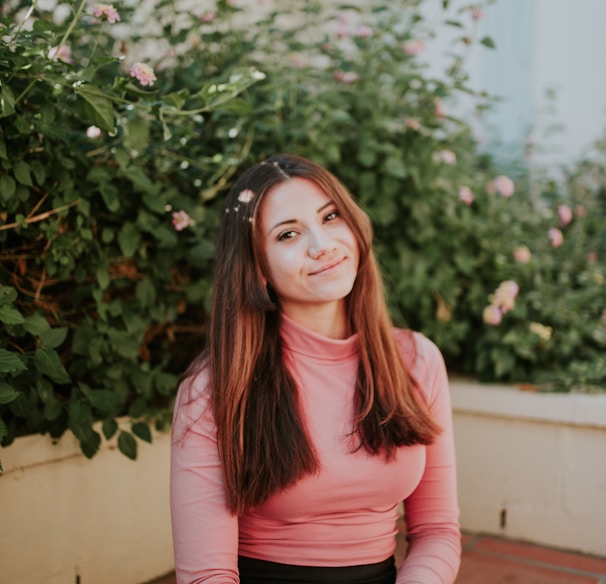 woman sitting near pink flowers at daytime