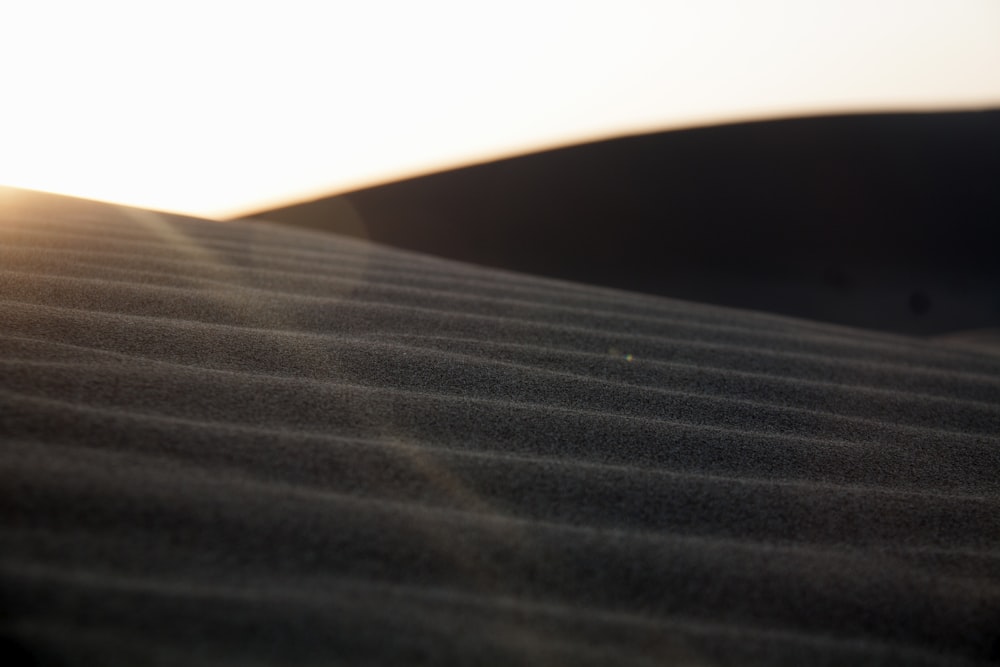 the sun is setting over the sand dunes