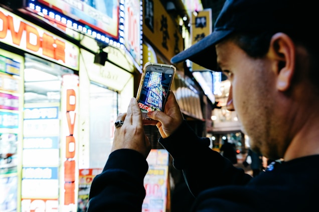 A smiling traveler using a smartphone with a vibrant Tokyo cityscape in the background.