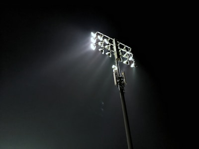 The gleaming pitch of Stamford Bridge under bright stadium lights at dusk.