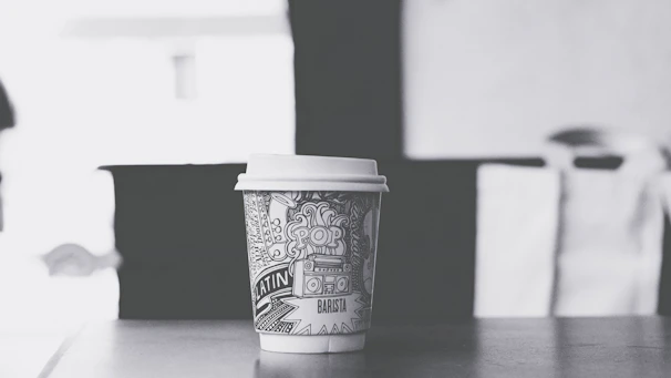 Close-up of a café menu and takeaway coffee cup featuring bright, fun illustrations and bold typography.