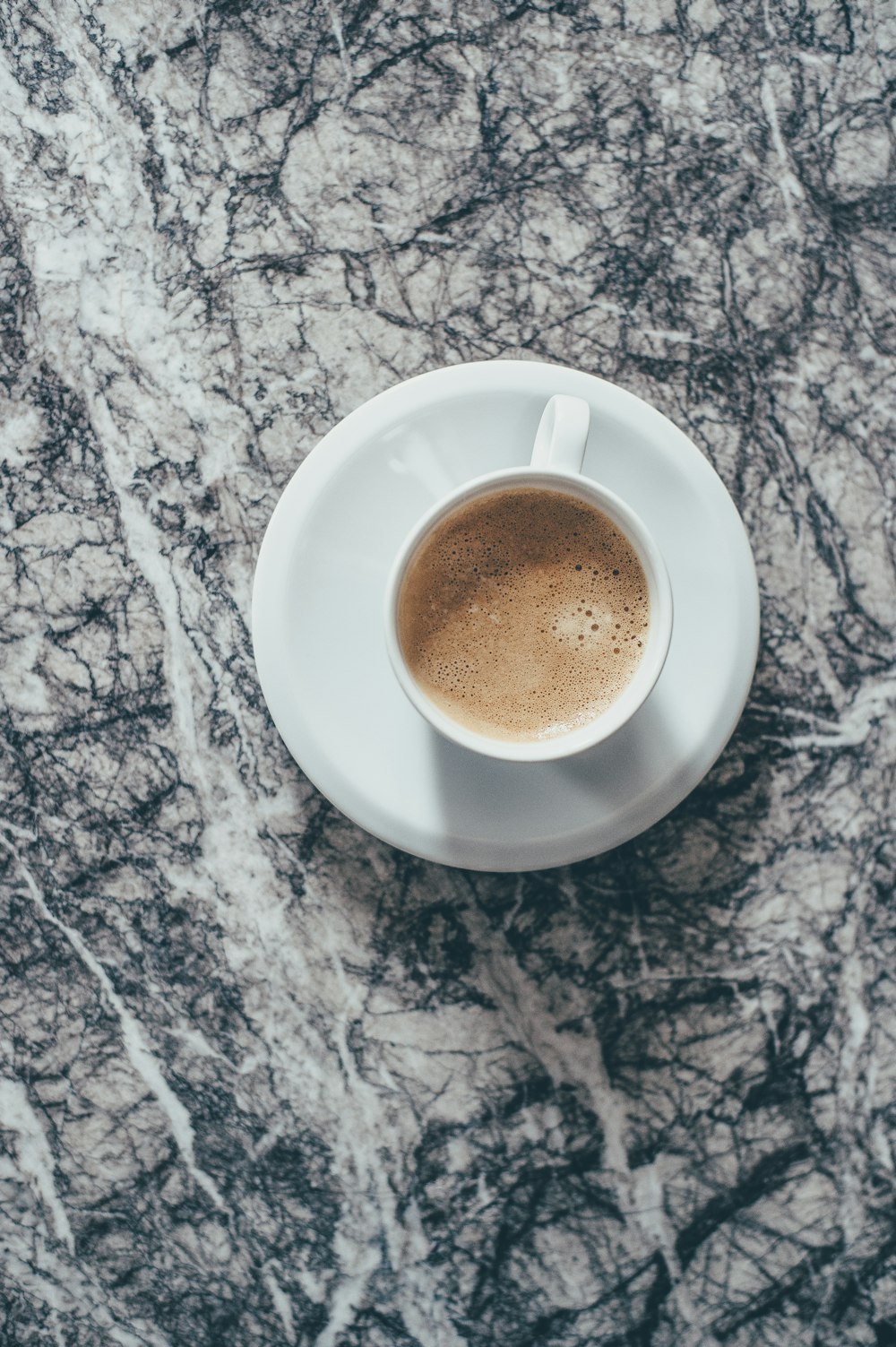 white ceramic coffee cup on white ceramic saucer