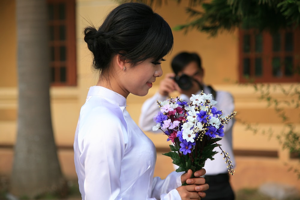 mulher segurando buquê de flores de cores variadas