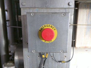 Close-up of safety signs and emergency stop buttons on industrial machines.
