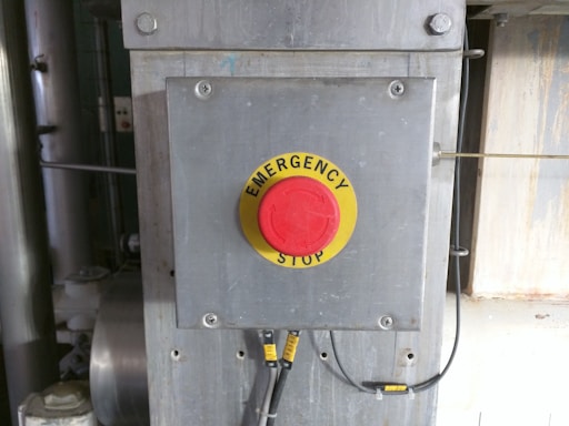 A close-up of a hand pressing a red emergency button symbolizing nuclear alert.