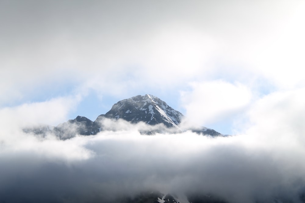 Montanha negra coberta de nuvens brancas