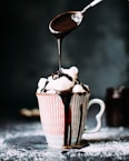 chocolate pouring on vanilla ice cream in ceramic cup