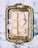 An ornate, vintage-style metal tray holds six rectangular shortbread cookies, arranged on a piece of parchment paper. Around these cookies are decorative paper snowflakes and golden curling ribbon. The tray is set on a marbled surface.