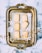 An ornate, vintage-style metal tray holds six rectangular shortbread cookies, arranged on a piece of parchment paper. Around these cookies are decorative paper snowflakes and golden curling ribbon. The tray is set on a marbled surface.