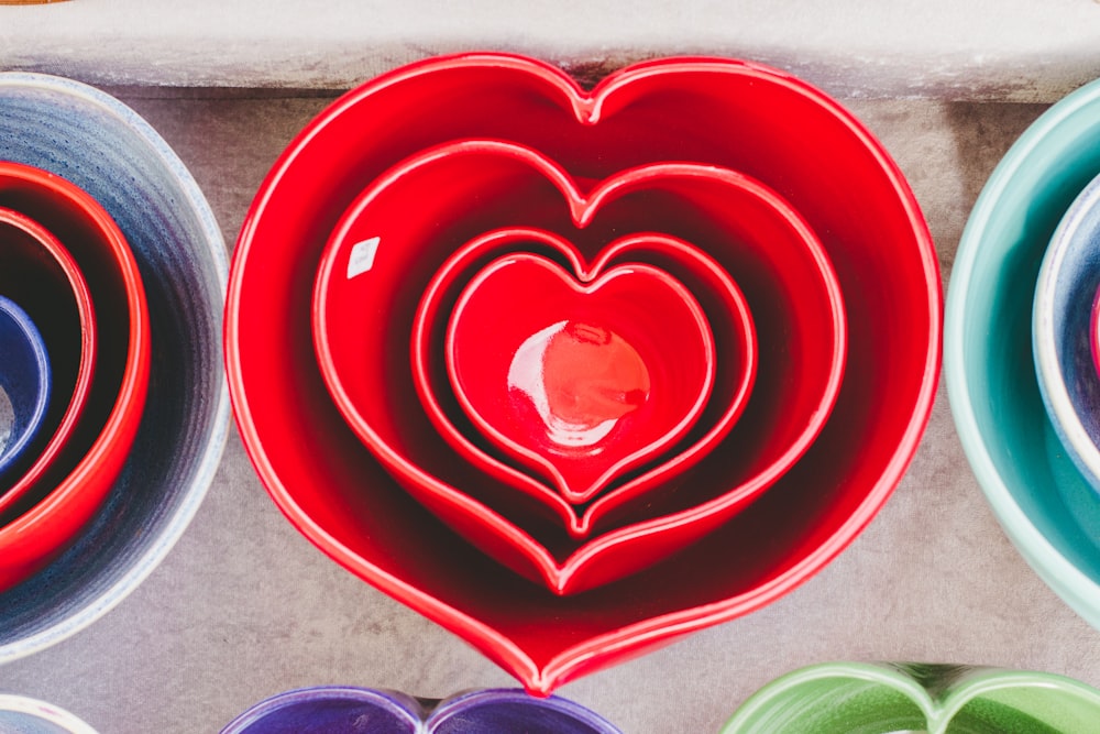 Red heart-shaped ceramic bowls of different sizes stacked one inside the other
