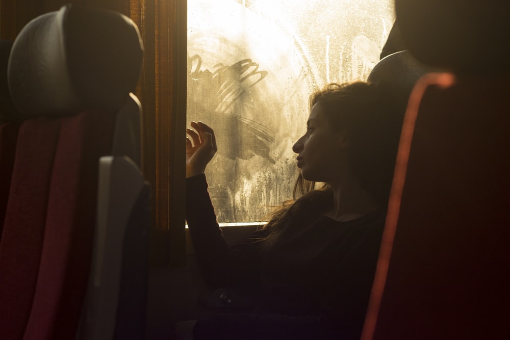 woman sitting on chair near window