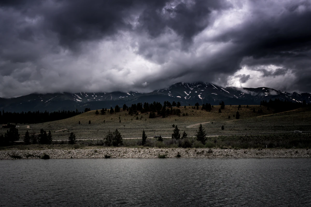Storm clouds over a snowy range near Leadville, with a lake in front