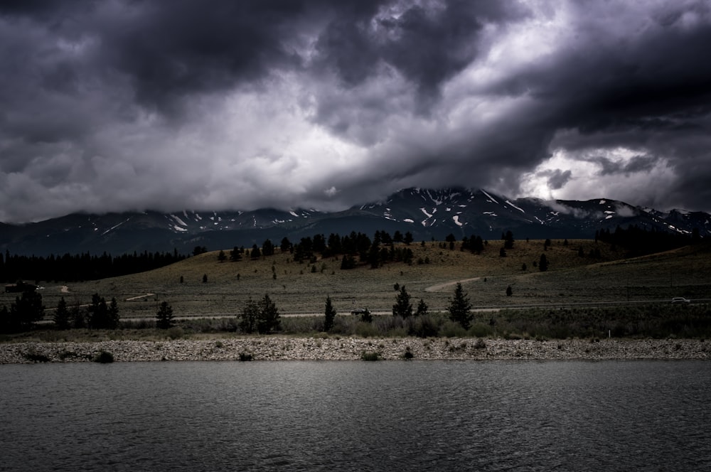 landscape photo of mountain with trees near body of water