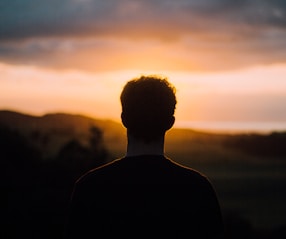 silhouette of a man facing the sunset