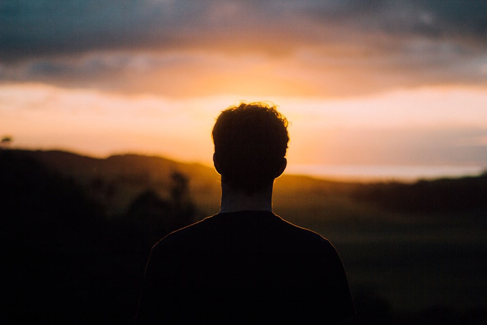 silhouette di un uomo di fronte al tramonto