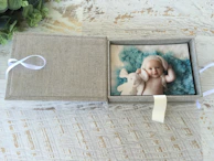 A delicate baby-themed box with customized items, soft pastel colors and gentle textures.