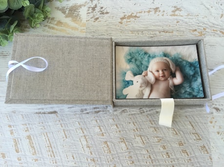 A charming gift box filled with personalized baby accessories and small toys.
