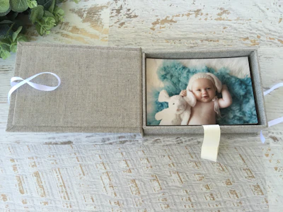 Soft pastel-hued personalized baby blankets neatly folded inside a sleek, branded velouré box.