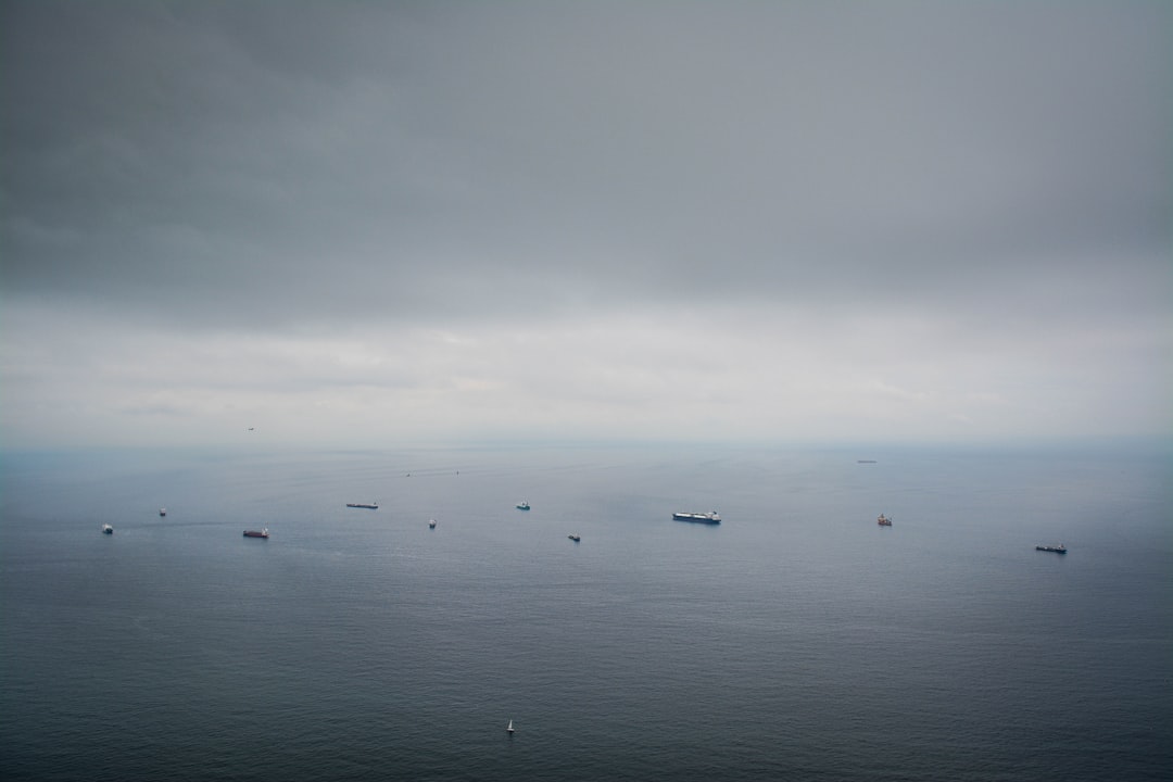 boats on calm sea under dim sky