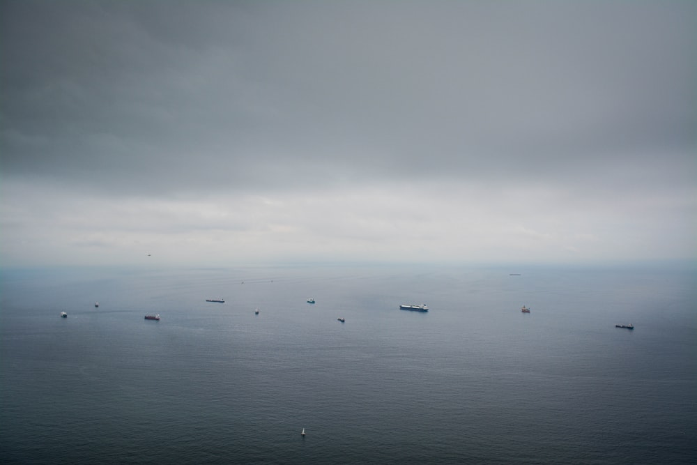 boats on calm sea under dim sky