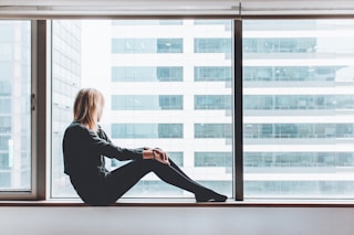 woman sitting on window