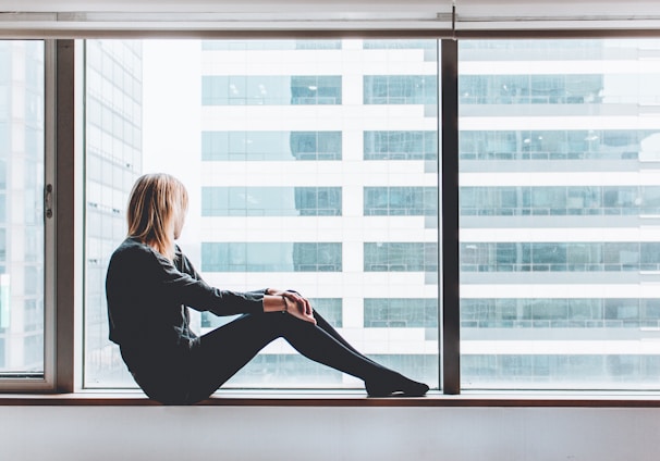 woman sitting on window