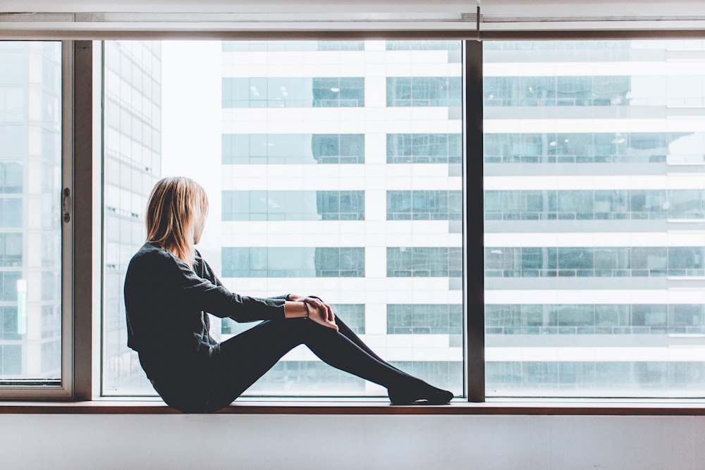 Frau sitzt am Fenster