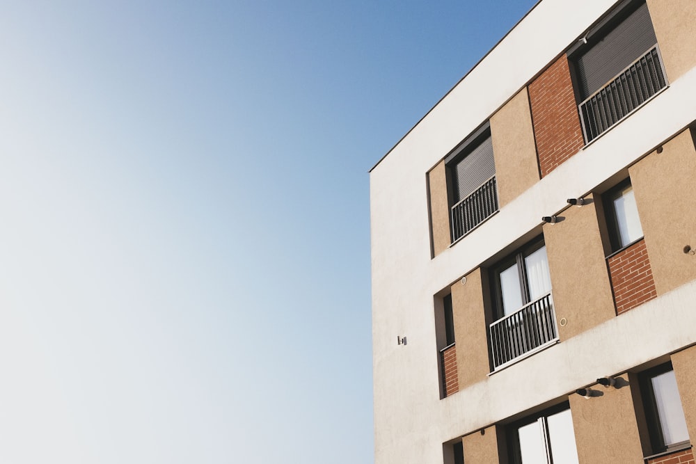 Edificio de hormigón blanco y marrón bajo el cielo azul durante el día