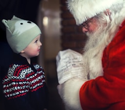Père Noël regardant un enfant et lui offrant un cadeau pour Noël
