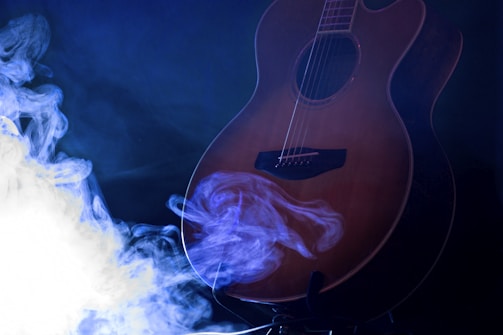 Close-up of musical instruments bathed in warm amber light with subtle smoke.
