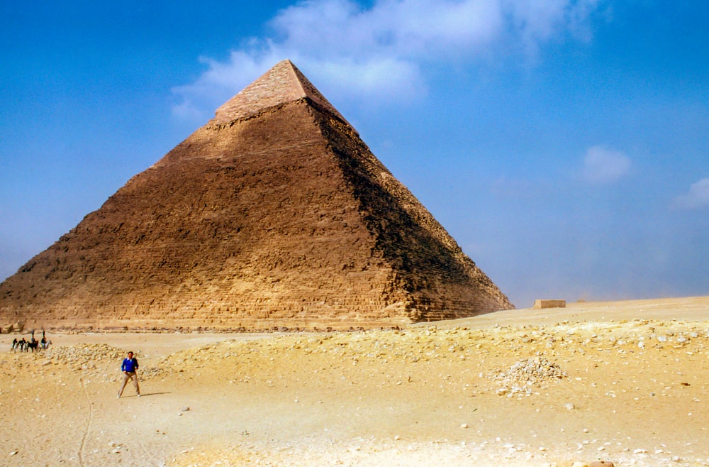 昼間、ピラミッド・ギザのそばに立つ男性