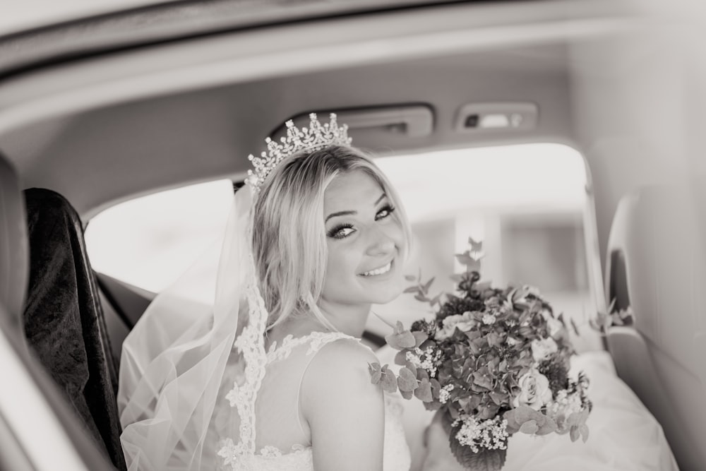 grayscale photo of girl in white sleeveless dress holding bouquet of flowers