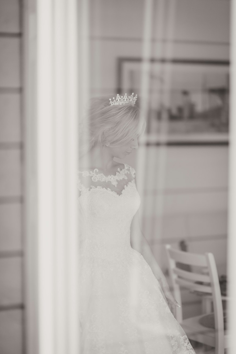 woman in white floral dress standing near window