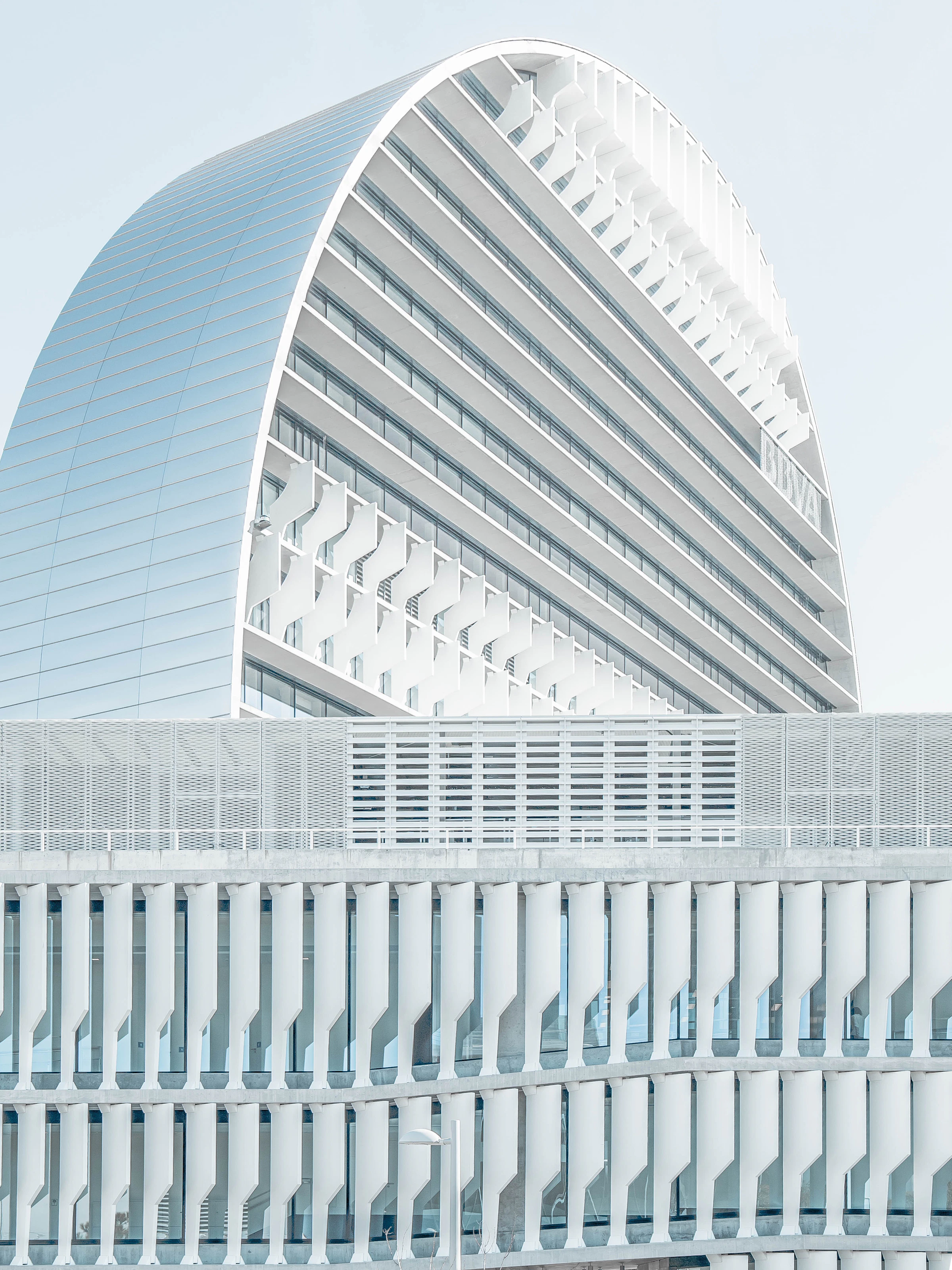 White facade, vertical fins, and reflected sky in Madrid. Reference photograph by Joel Filipe.